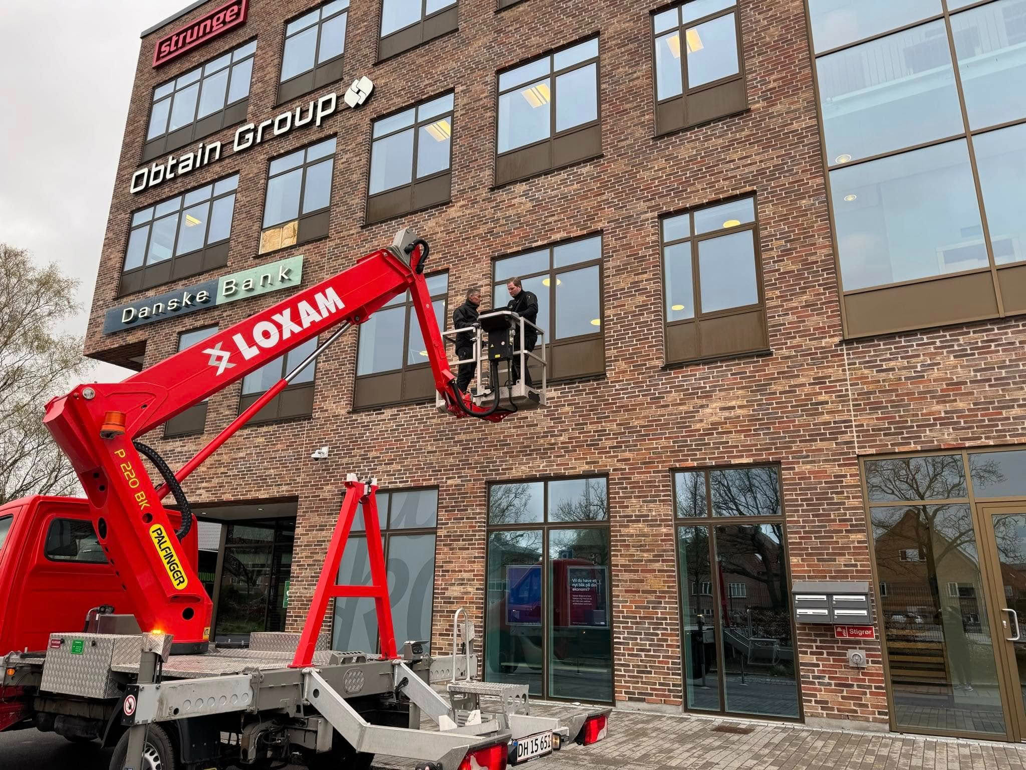Højdearbejde på kontorbygning med lift monteret på lastbil.