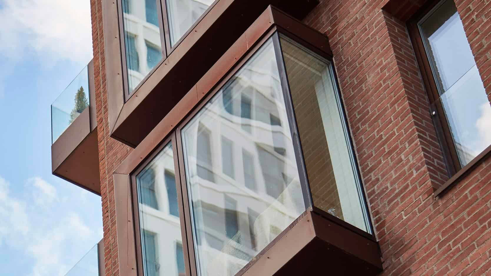 Moderne forbedrede vinduer på attraktivt murstensbyggeri.