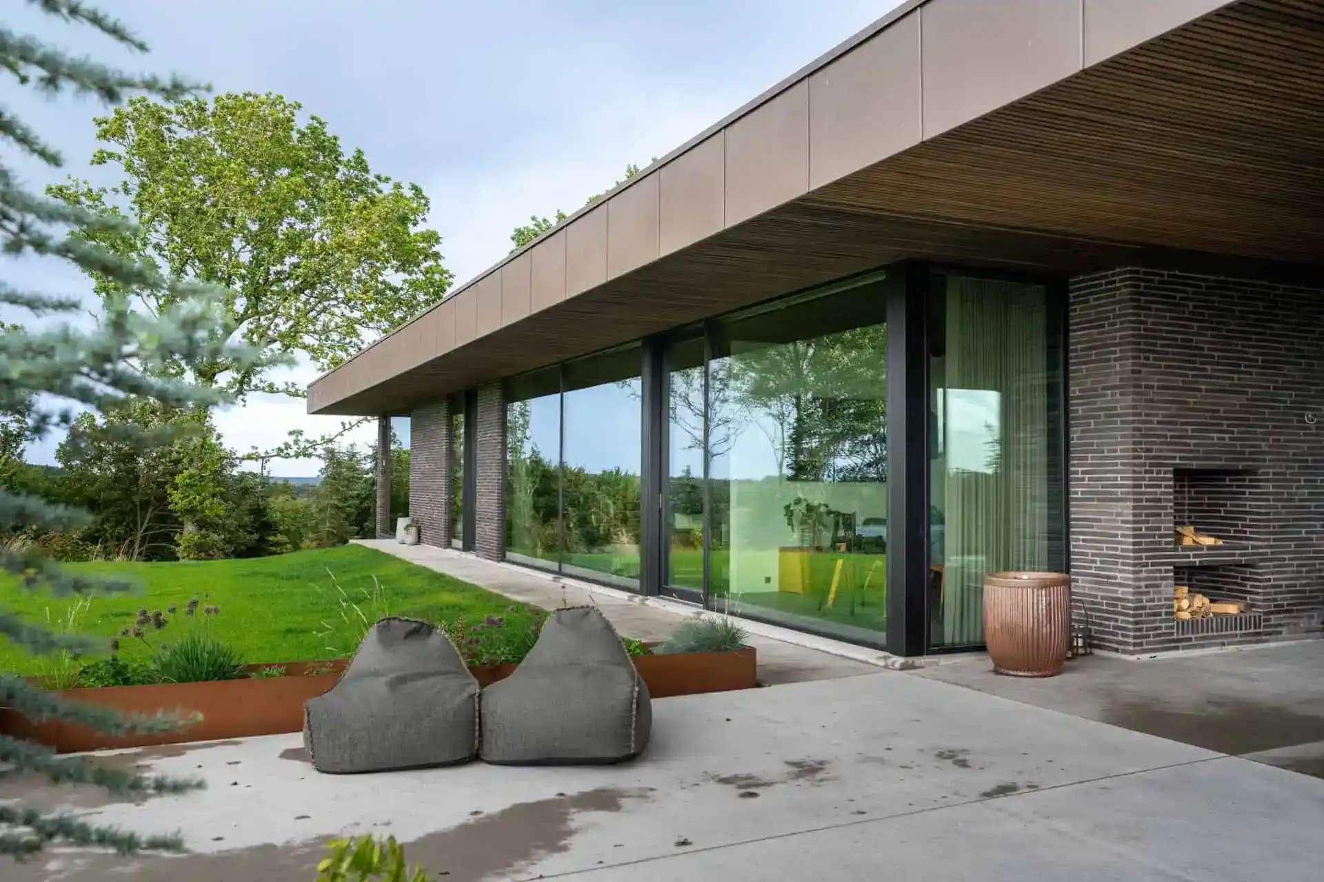 Foldedøre i moderne villa med store glasfacader og have.