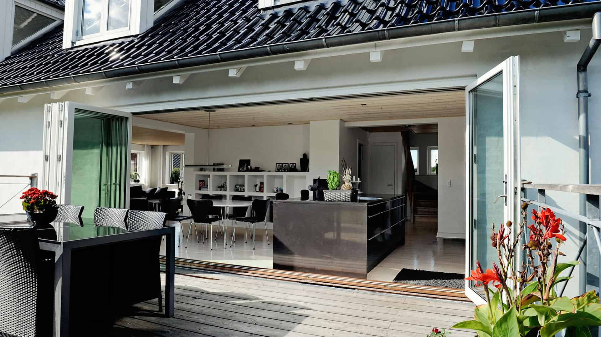 Lette-udkast til et billede af et moderne hjem med store glasdøre ud til terrasse.