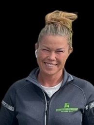 Højtaljede kvinder med smart, blåt sportstrøje, smilende foran en neutral baggrund.