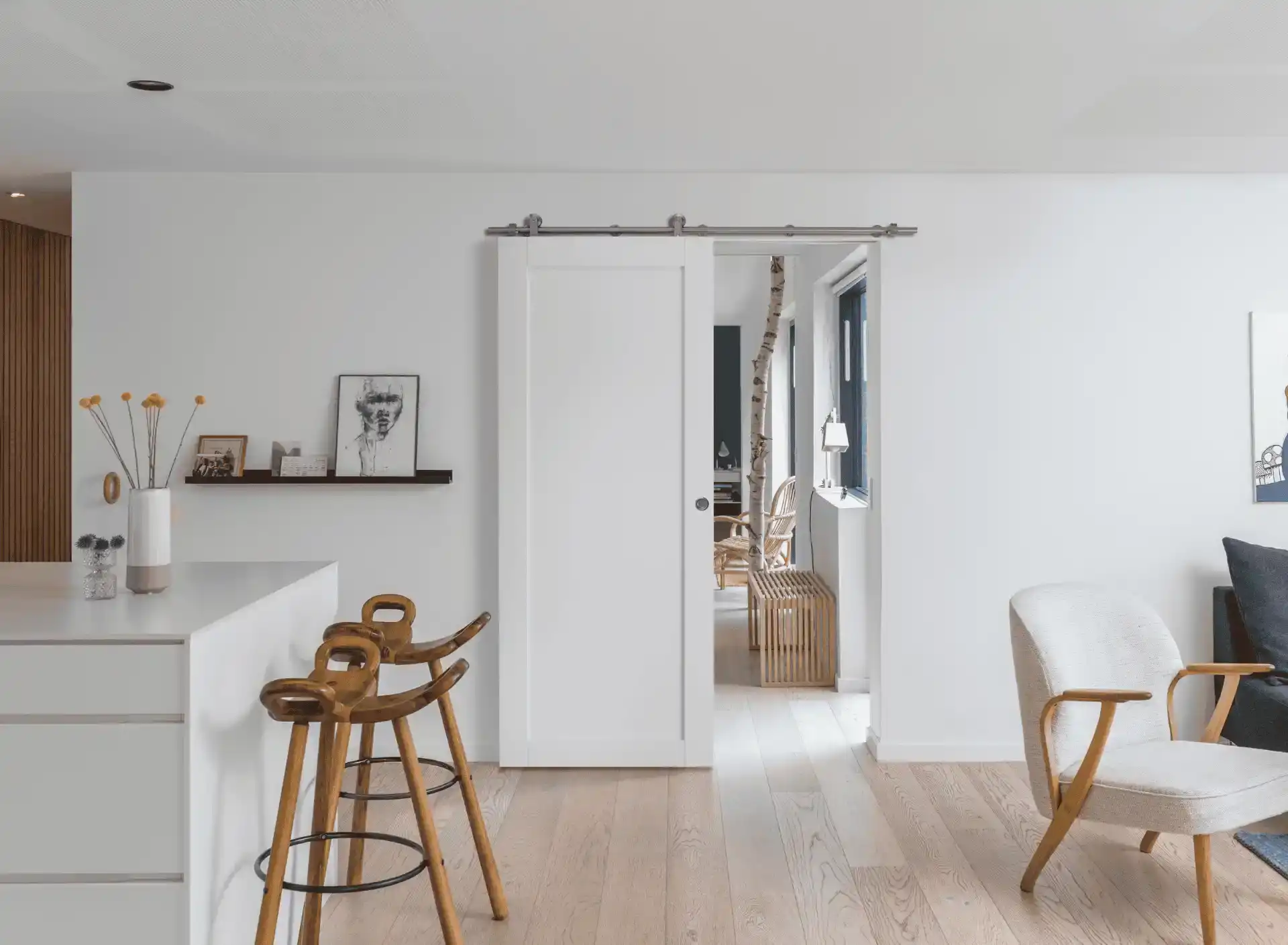 Lyst indretning med moderne hvide vægge og træmøbler i et lyst hjem.