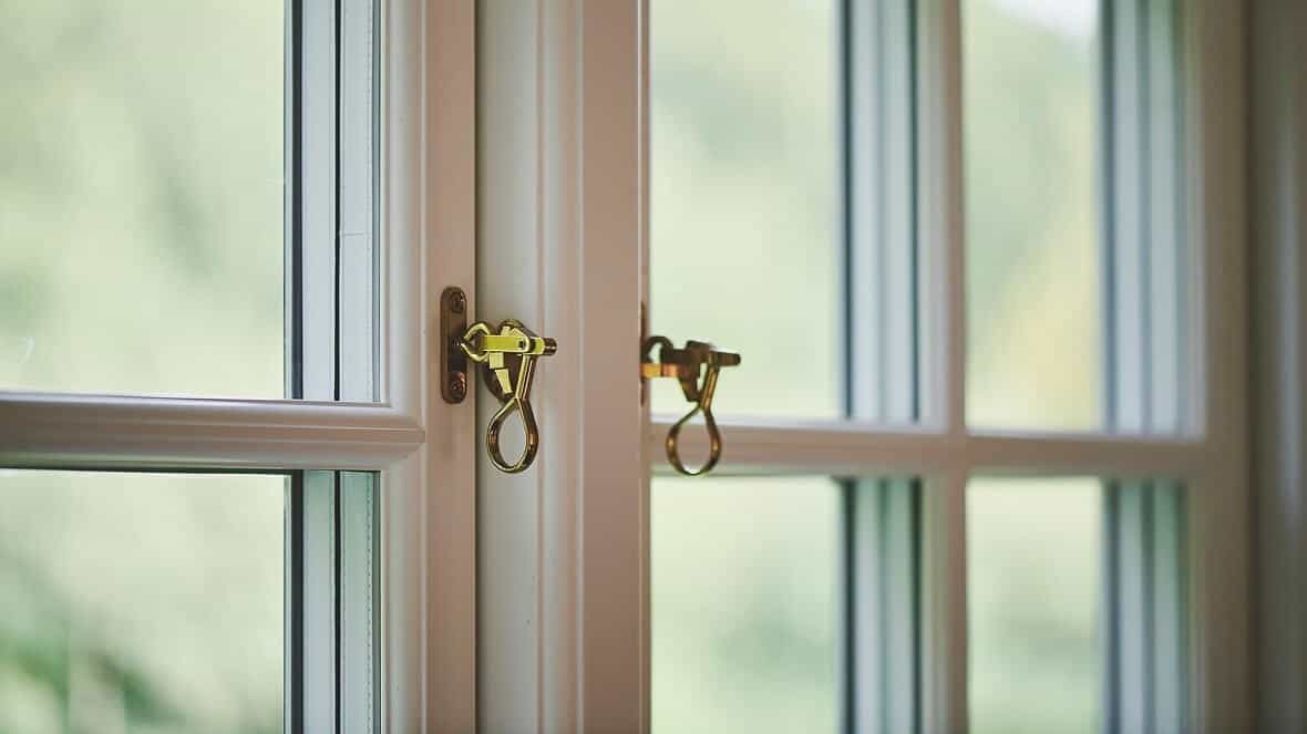 Hvælving af vinduer med gyldne låse og udendørs udsigt.