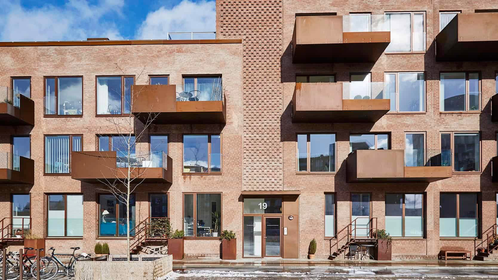 Elegant lejlighedskompleks med store, moderne vinduer og charmerende terrasser.