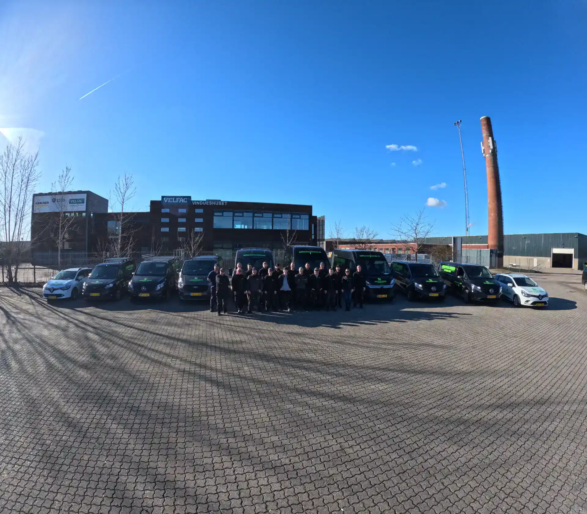 1. Moderne erhvervsvogne parkeret foran en kontorbygning under en klar blue sky.