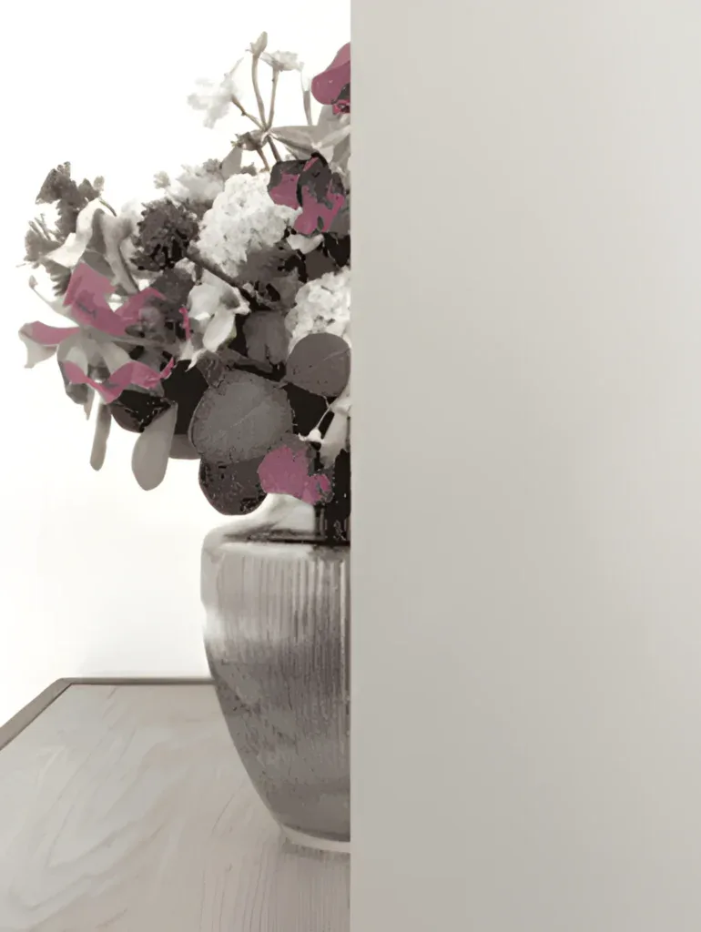 Kunstnerisk opstilling med bundt blomster i en vaser, dominant visning i minimalistisk indretning.