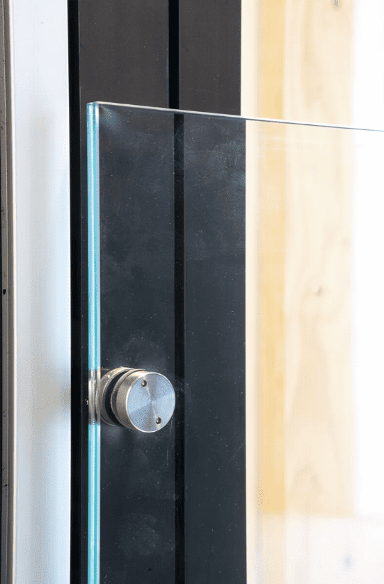 Elegant glasdør med sort ramme og rustfrit håndtag til moderne hjem.