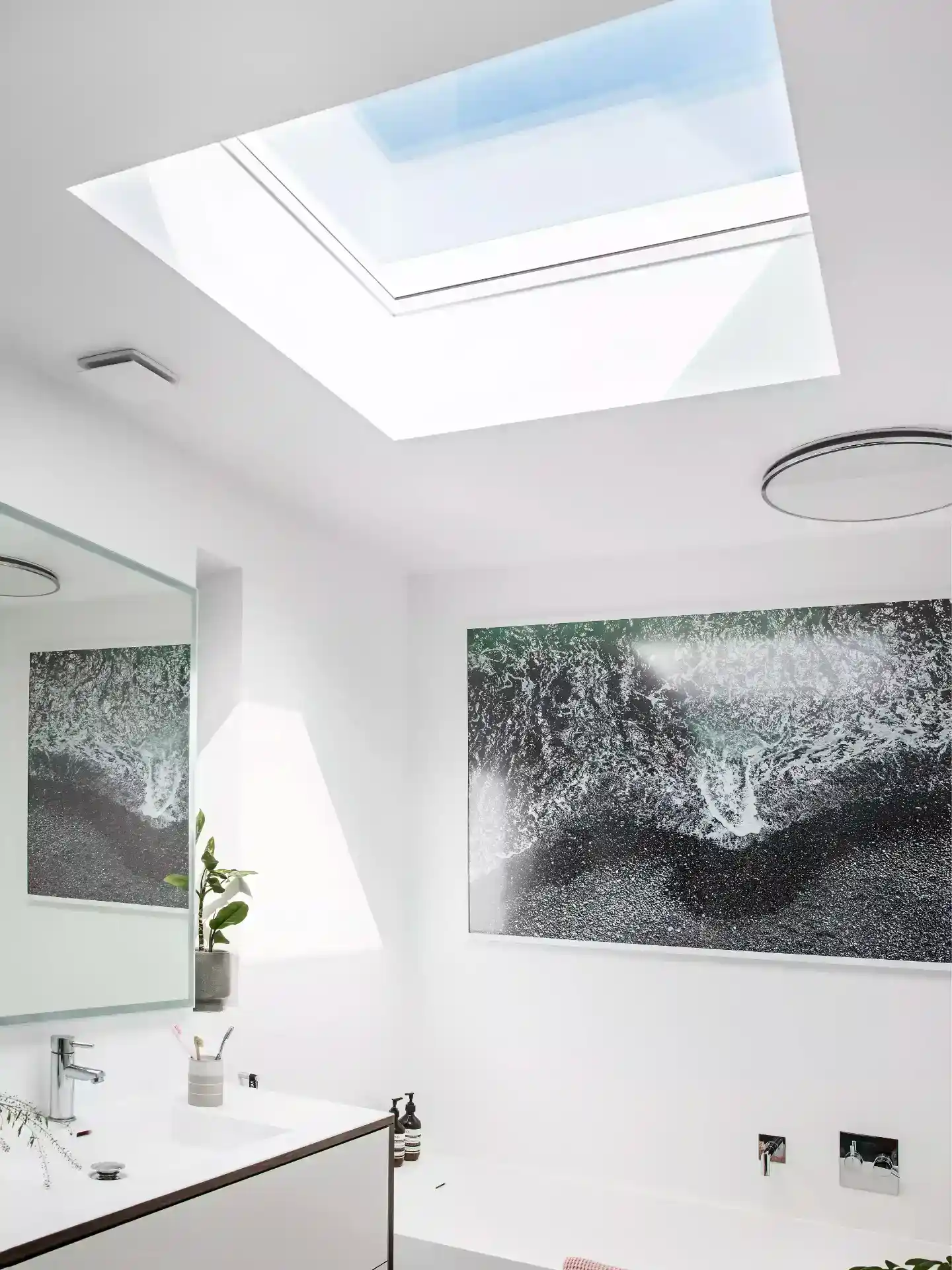 Skylight til badeværelse med naturligt lys og moderne hvide vægge.