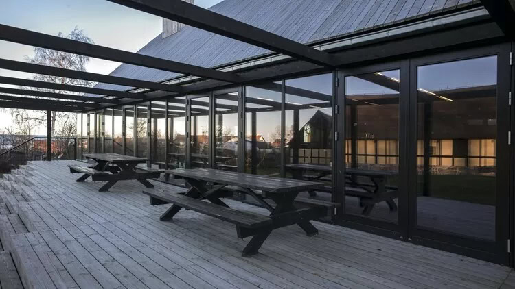 Alt tekst: Moderne skærmsamling med store glasfacader og roverdæk.