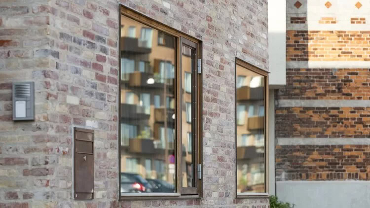 Moderne træ-rammede vinduer i murstensbygning.