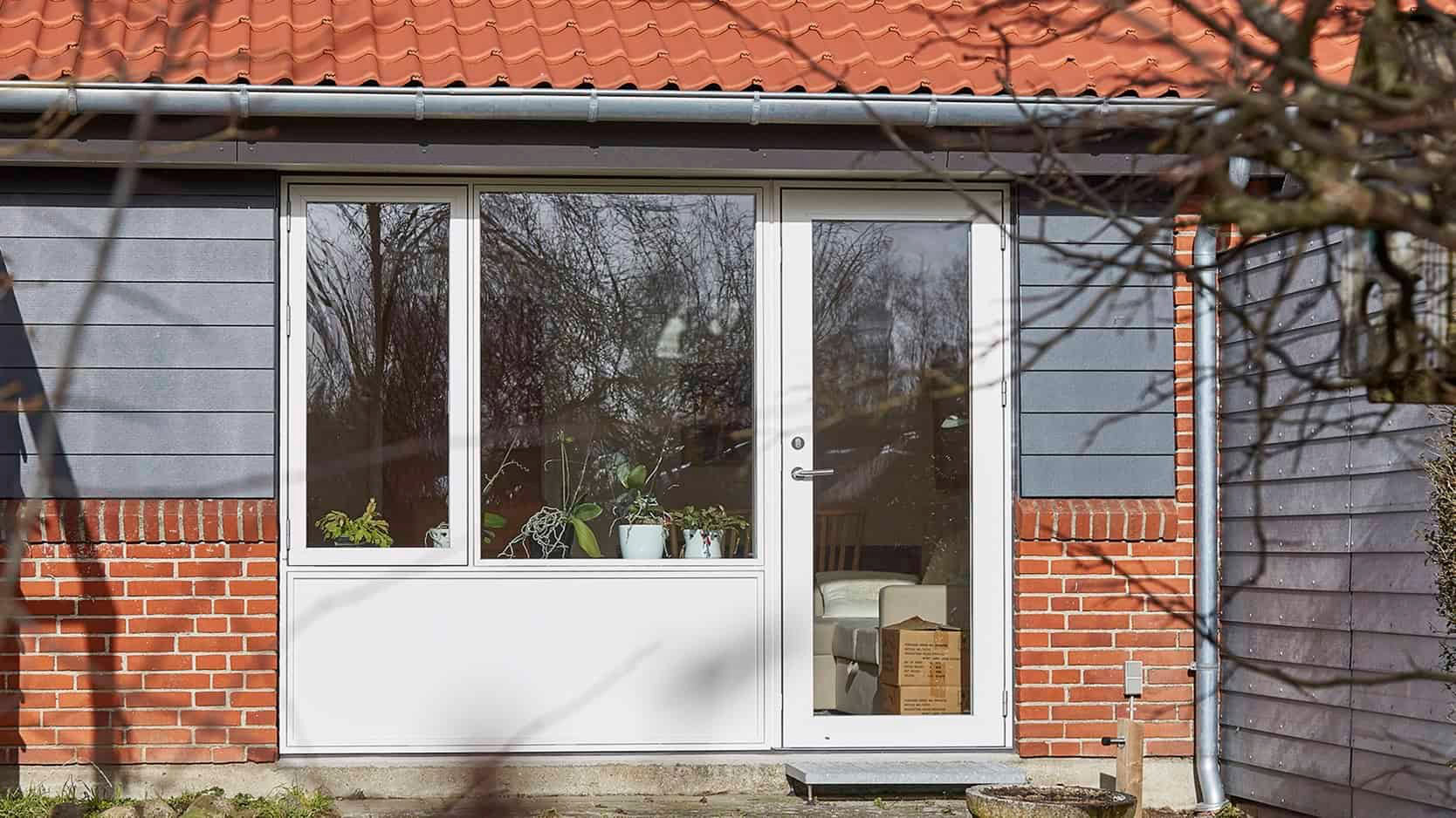 Moderne hvide altanlåger med store glasruder i privat hus.