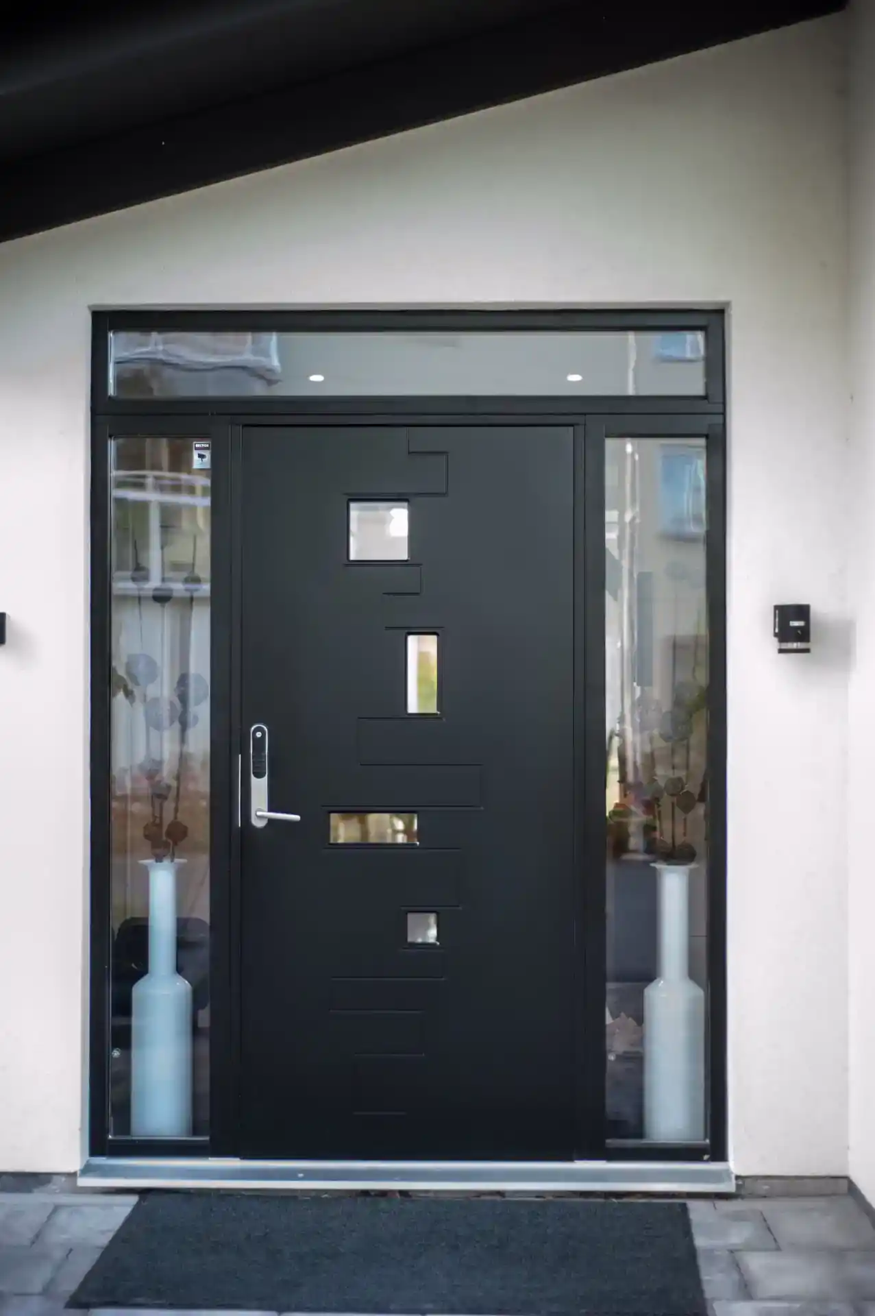 Sydkystens vinduer, moderne sort dør med sidepartier og glasbånd, flot indgang til hjemmet.