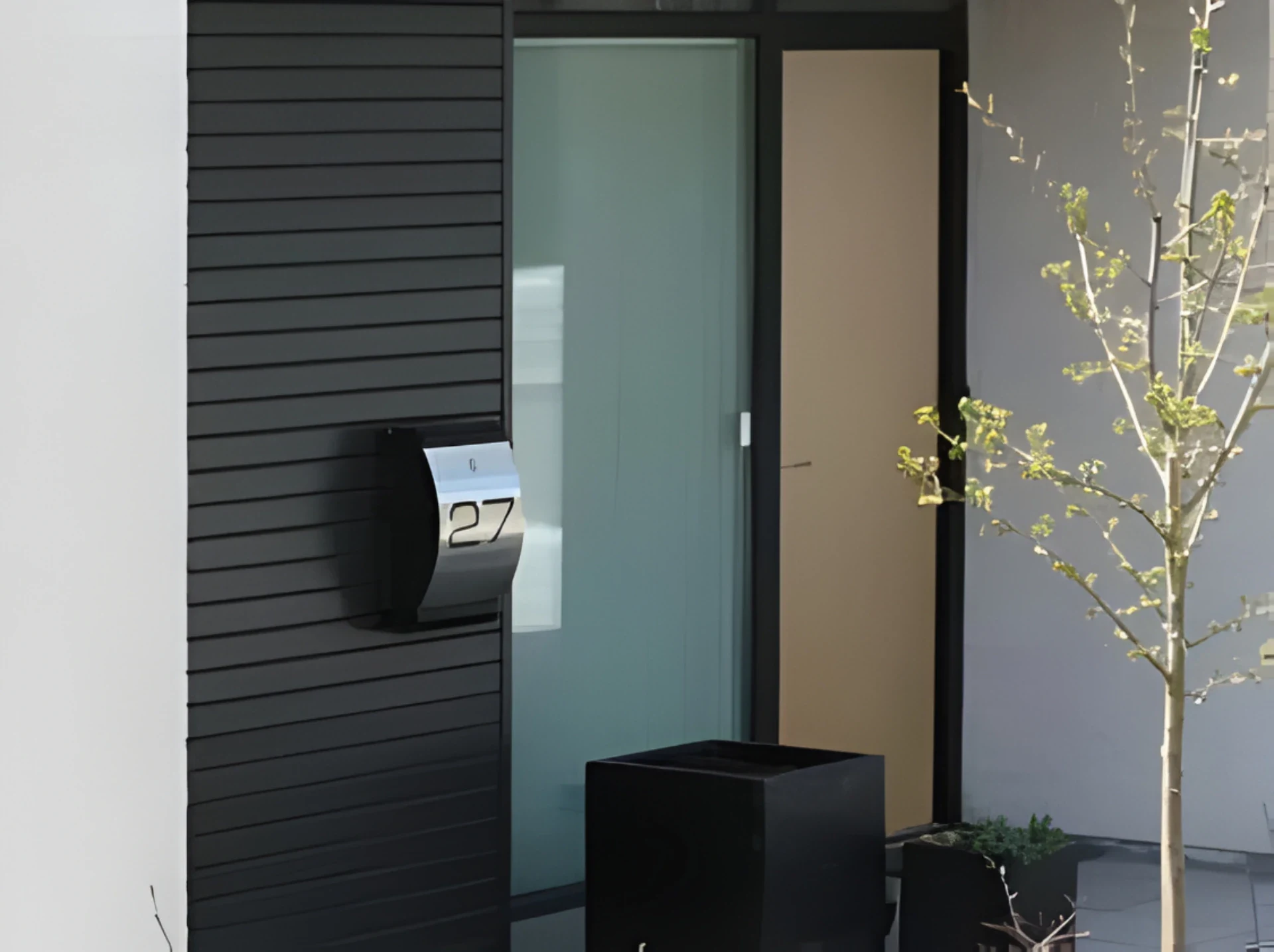 Moderne glas- og træindgangsportal med minimalistisk design og sort, hvid og beige farveskala.